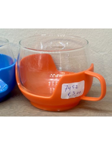 Tea glass in orange coloured plastic holder - unmarked - 1970s